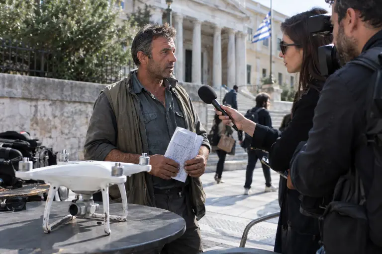 Outside the Athens Administrative Court, an olive grower speaks to journalists beside an impounded drone after exhibits were ordered released, Athens, 22 September 2026.