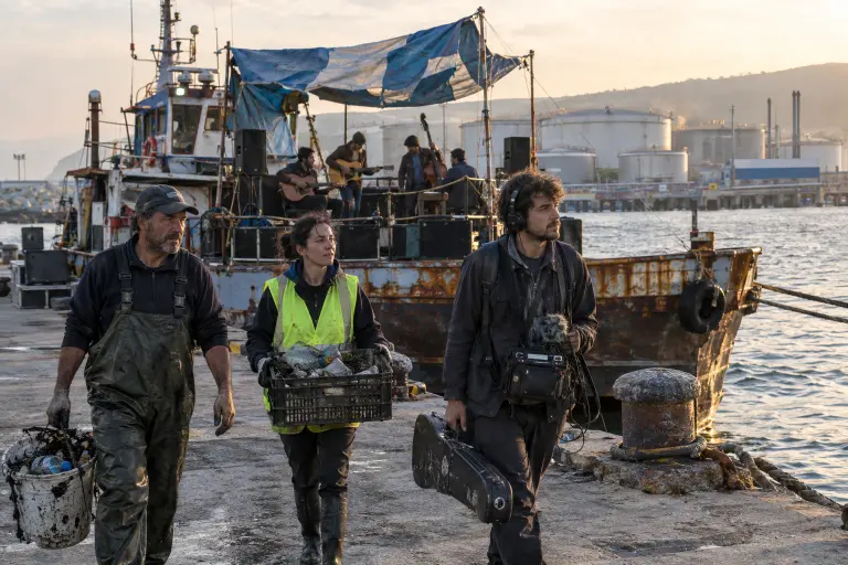 Volunteers load sorted, oily plastic onto a converted skimmer at Aliağa harbour, where musicians recorded tracks for the recycled‑vinyl album. Photo by a local photographer, 18 Sept 2026.