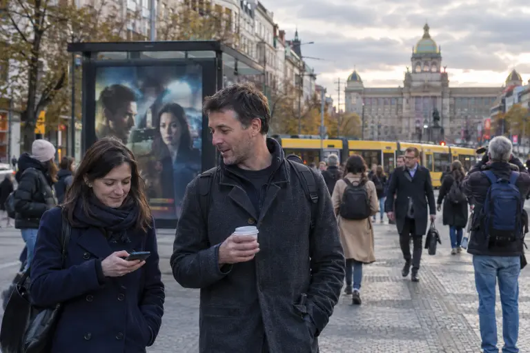 Commuters watch a promotional image for Vltava Nights on a billboard in Wenceslas Square, Prague.