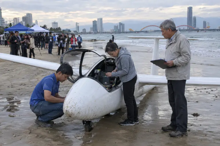 The winning glider on My Khe beach after its 20 September run, Da Nang — engineers inspect instruments as journalists look on.