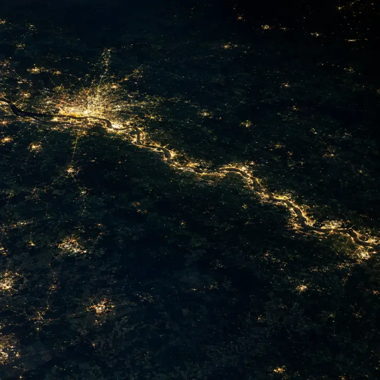 Night‑time imagery shows a continuous luminescent band along the Elbe, mapped from space.