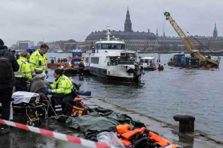 Rescue crews on the quay near Slotsholmen help survivors after a commuter ferry collided with a repair barge beside the parliamentary islet, Copenhagen.