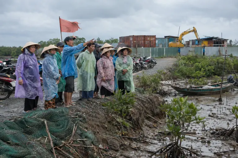 Fisherfolk block a coastal access road outside a construction compound in Can Gio, Ho Chi Minh City province, on Monday as activists protest the new seawall project.