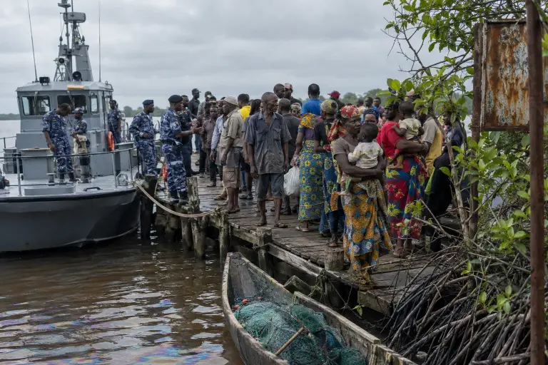 Residents and navy personnel at Brass jetty at dawn after offshore platforms were seized, Bayelsa State.