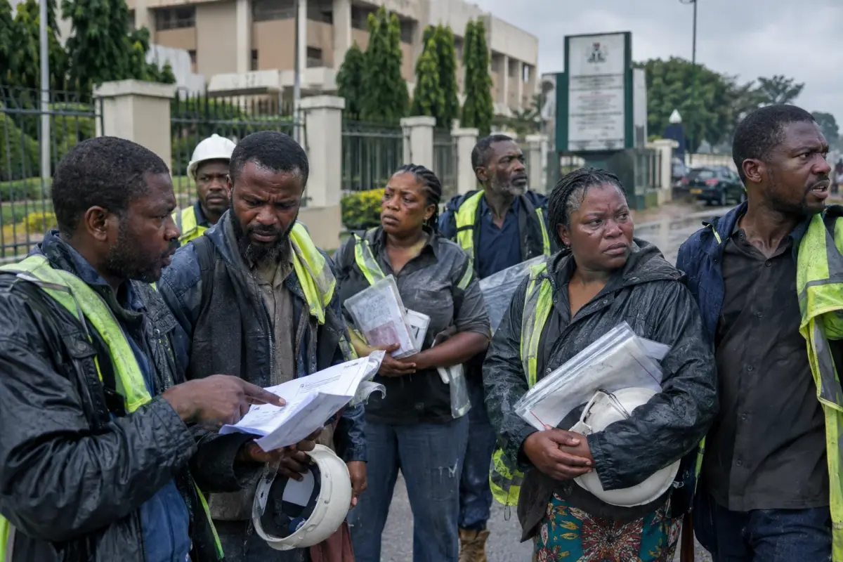 Small contractors outside the Ministry of Infrastructure in Abuja holding copies of disputed invoices from the leaked ledger, 21 September.
