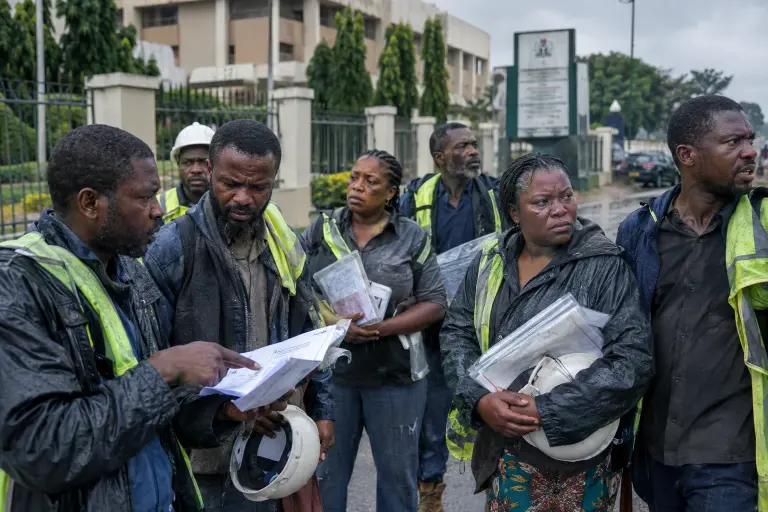 Small contractors outside the Ministry of Infrastructure in Abuja holding copies of disputed invoices from the leaked ledger, 21 September.