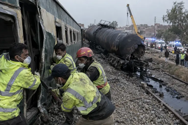 Rescuers work at the scene near Kotri Bridge as a damaged tank car leaks and commuters are pulled from scorched carriages, 21 September.