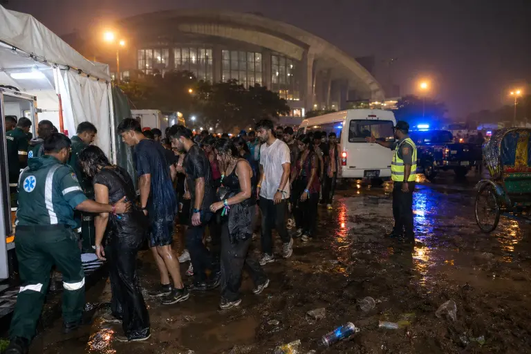 Festivalgoers escorted to a triage tent outside BICC after an atmospheric spray sent hundreds fainting on Sunday night in Dhaka.